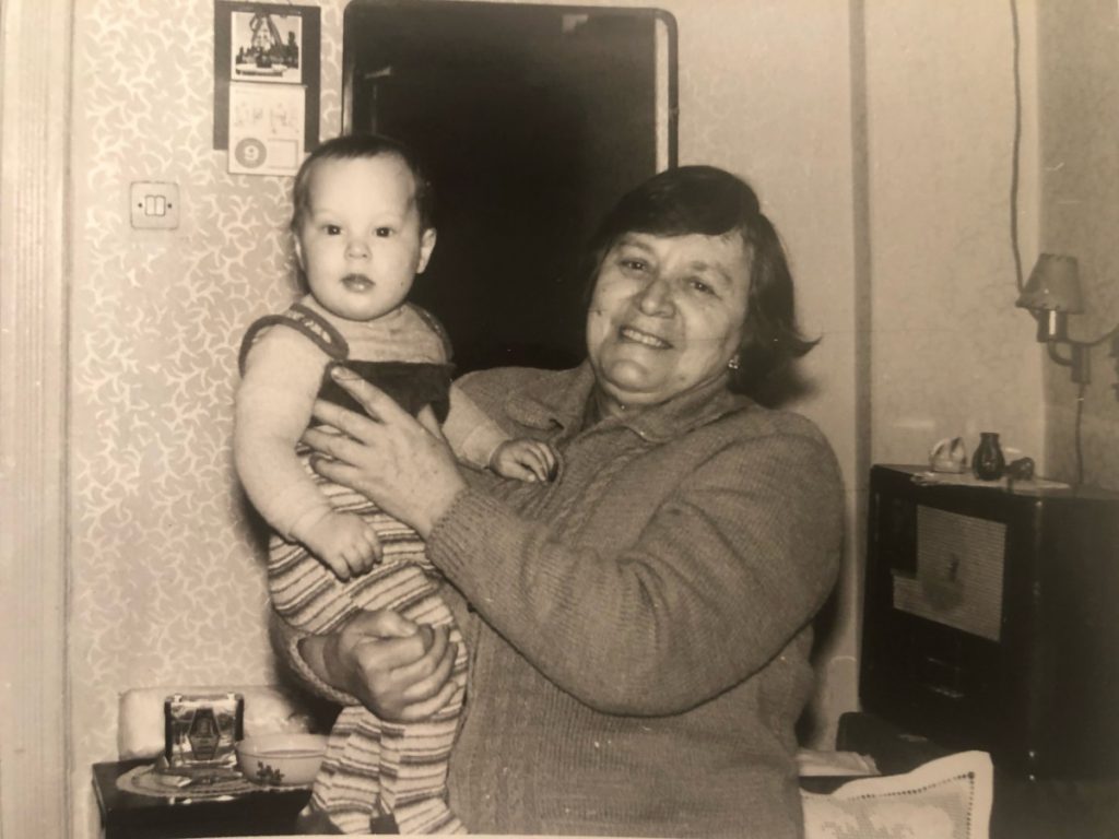 o poza veche cu o femeie in varsta care tine un copil in brate